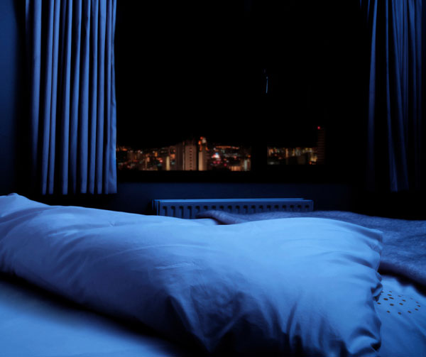 You can prevent heat absorption in the air and bedding by keeping as much light out of your bedroom during the day.